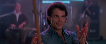 Movie still from “Road House” (1989), directed by Rowdy Herrington – A person holding a stick in a room; Close Up shot, Low angle