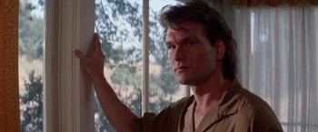 Movie still from “Road House” (1989), directed by Rowdy Herrington – A person standing near a window; Close Up shot, Low angle