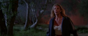 Movie still from “Road House” (1989), directed by Rowdy Herrington – A woman standing in front of a forest at night; Medium shot, Low angle