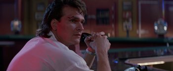 Movie still from “Road House” (1989), directed by Rowdy Herrington – A person using a cell phone; Close Up shot, Low angle