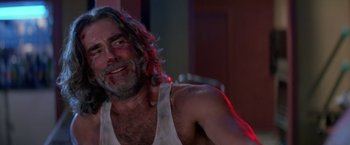 Movie still from “Road House” (1989), directed by Rowdy Herrington – A man with long hair and a white tank top; Close Up shot, Low angle