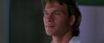 Movie still from “Road House” (1989), directed by Rowdy Herrington – A man's face in a dark room; Close Up shot, Low angle