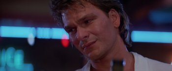 Movie still from “Road House” (1989), directed by Rowdy Herrington – A person with a sad face; Close Up shot, Over the shoulder angle
