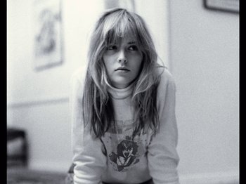 Movie still from “Rolling Thunder Revue” (2019), directed by Martin Scorsese – A woman with long hair sitting on the ground; Close Up shot, Low angle
