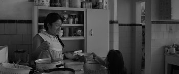 Movie still from “Roma” (2018), directed by Alfonso Cuarón – A woman and a child in a kitchen; Medium shot, Over the shoulder angle