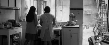 Movie still from “Roma” (2018), directed by Alfonso Cuarón – Two women standing at a kitchen counter preparing a meal; Medium shot, Low angle