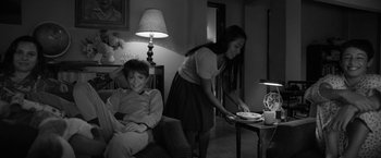 Movie still from “Roma” (2018), directed by Alfonso Cuarón – A woman and a boy in a living room setting; Medium shot, Over the shoulder angle