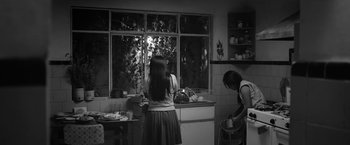 Movie still from “Roma” (2018), directed by Alfonso Cuarón – Two women in a kitchen looking out a window; Wide shot, Low angle