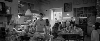 Movie still from “Roma” (2018), directed by Alfonso Cuarón – A group of people sitting at tables in a restaurant; Wide shot, Over the shoulder angle