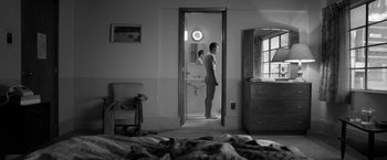 Movie still from “Roma” (2018), directed by Alfonso Cuarón – A man standing in front of a mirror in a bathroom; Wide shot, High angle