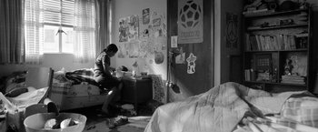 Movie still from “Roma” (2018), directed by Alfonso Cuarón – A woman sitting at a desk in a room; Wide shot, High angle