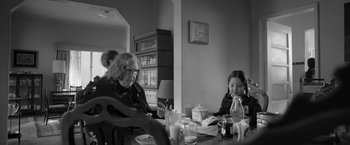 Movie still from “Roma” (2018), directed by Alfonso Cuarón – Two people sitting at a dining table eating food; Medium shot, Over the shoulder angle