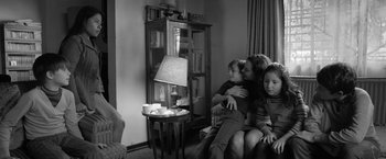 Movie still from “Roma” (2018), directed by Alfonso Cuarón – A group of people sitting in a living room together; Medium shot, High angle