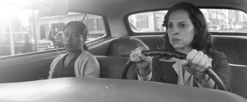 Movie still from “Roma” (2018), directed by Alfonso Cuarón – Two women sitting in the back seat of a car; Medium shot, Over the shoulder angle