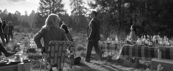Movie still from “Roma” (2018), directed by Alfonso Cuarón – A black and white photo of people sitting at a table outside; Wide shot, Over the shoulder angle