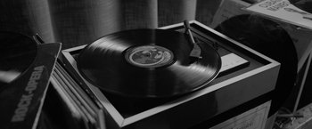 Movie still from “Roma” (2018), directed by Alfonso Cuarón – A record player with a record on top of it in black and white; Extreme Close Up shot, High angle