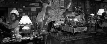 Movie still from “Roma” (2018), directed by Alfonso Cuarón – A woman sitting on the floor in front of a christmas tree; Wide shot, High angle