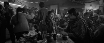 Movie still from “Roma” (2018), directed by Alfonso Cuarón – A group of people sitting at a table with drinks; Medium shot, Over the shoulder angle