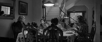 Movie still from “Roma” (2018), directed by Alfonso Cuarón – A group of people sitting around a table eating food; Wide shot, High angle