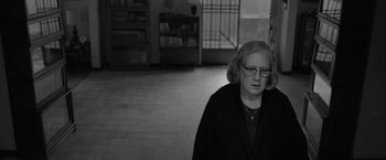 Movie still from “Roma” (2018), directed by Alfonso Cuarón – An older woman wearing glasses standing in an empty room; Close Up shot, Over the shoulder angle