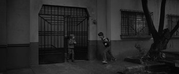 Movie still from “Roma” (2018), directed by Alfonso Cuarón – Two young boys are playing a game of baseball; Wide shot, High angle