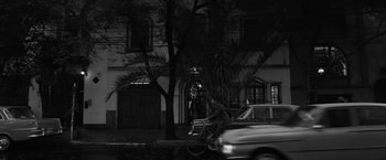 Movie still from “Roma” (2018), directed by Alfonso Cuarón – A man riding a bike down a street next to parked cars; Extreme Wide shot, Low angle