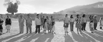 Movie still from “Roma” (2018), directed by Alfonso Cuarón – A black and white photo of a group of people standing in the sand; Wide shot, Over the shoulder angle