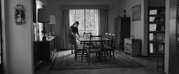 Movie still from “Roma” (2018), directed by Alfonso Cuarón – A woman in a dining room setting with a table and chairs; Wide shot, High angle