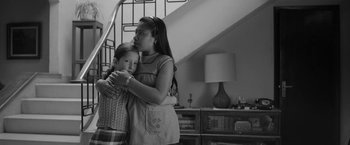 Movie still from “Roma” (2018), directed by Alfonso Cuarón – A woman and a child are hugging in a room; Medium shot, High angle