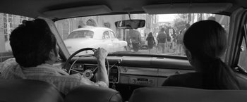 Movie still from “Roma” (2018), directed by Alfonso Cuarón – A black and white photo of a person driving a car; Wide shot, Over the shoulder angle