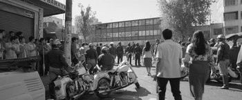 Movie still from “Roma” (2018), directed by Alfonso Cuarón – A black and white photo of a group of people standing on the side of the street; Wide shot, High angle