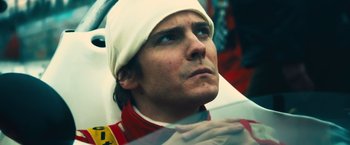 Movie still from “Rush” (2013), directed by Ron Howard – A person in a race car; Close Up shot, Low angle