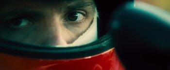 Movie still from “Rush” (2013), directed by Ron Howard – A person wearing a helmet; Extreme Close Up shot, Overhead angle