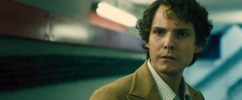 Movie still from “Rush” (2013), directed by Ron Howard – A person wearing a suit and tie; Close Up shot, Over the shoulder angle