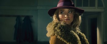 Movie still from “Rush” (2013), directed by Ron Howard – A woman wearing a purple hat and a fur coat; Close Up shot, Over the shoulder angle