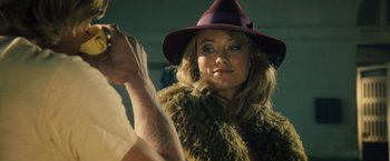 Movie still from “Rush” (2013), directed by Ron Howard – A woman wearing a purple hat and a fur coat; Close Up shot, Over the shoulder angle