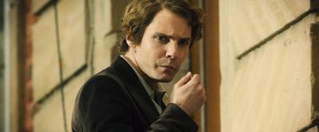 Movie still from “Rush” (2013), directed by Ron Howard – A person wearing a suit and tie; Close Up shot, Over the shoulder angle