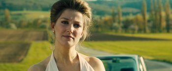 Movie still from “Rush” (2013), directed by Ron Howard – A beautiful woman standing in front of a car; Close Up shot, Over the shoulder angle