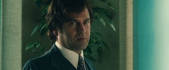 Movie still from “Rush” (2013), directed by Ron Howard – A person wearing a suit and tie; Close Up shot, Low angle