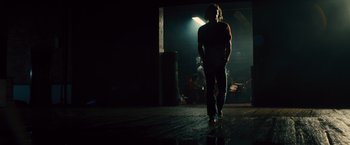 Movie still from “Rush” (2013), directed by Ron Howard – A man walking in the dark in front of a light; Wide shot, Low angle