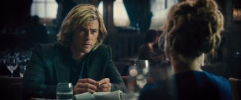 Movie still from “Rush” (2013), directed by Ron Howard – A man sitting at a table with a glass of wine in front of him; Close Up shot, Over the shoulder angle
