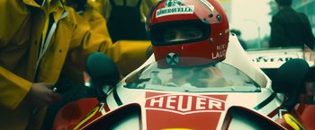Movie still from “Rush” (2013), directed by Ron Howard – A person in a racing car wearing a helmet; Close Up shot, Low angle