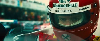 Movie still from “Rush” (2013), directed by Ron Howard – A person wearing a racing helmet; Close Up shot, Low angle