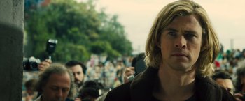 Movie still from “Rush” (2013), directed by Ron Howard – A person taking a picture of a crowd; Close Up shot, Over the shoulder angle