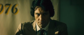 Movie still from “Rush” (2013), directed by Ron Howard – A person wearing a suit and tie; Close Up shot, Low angle