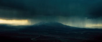 Movie still from “Rush” (2013), directed by Ron Howard – A view of a mountain range with a dark sky above it; Extreme Wide shot, High angle