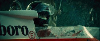 Movie still from “Rush” (2013), directed by Ron Howard – A person wearing a racing helmet in the rain; Extreme Close Up shot, High angle