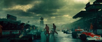 Movie still from “Rush” (2013), directed by Ron Howard – Two men are walking in the rain in a parking lot; Extreme Wide shot, Low angle