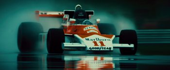 Movie still from “Rush” (2013), directed by Ron Howard – A racing car on a race track; Wide shot, Low angle