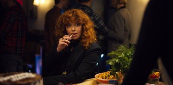 Movie still from “Russian Doll” (2019), created by Natasha Lyonne – A woman sitting in front of a bowl of food at a table; Medium shot, Over the shoulder angle